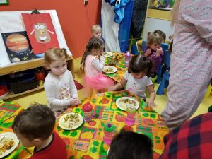 Toddlers enjoying a plateful of yummy food