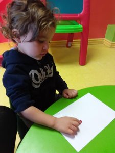 Toddler about to put red paint on paper