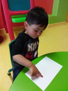 Toddler pressing finger on paper