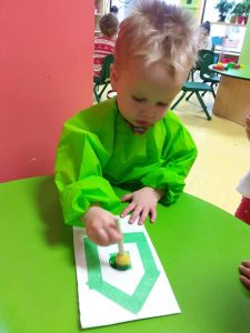 Toddler painting with green paint