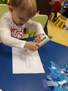 Toddler working on a dreidel art project
