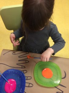 Kid painting nails using orange paint