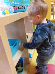 Toddler searching for easter eggs in a cubby