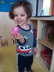 Toddler holding an easter egg and smiling