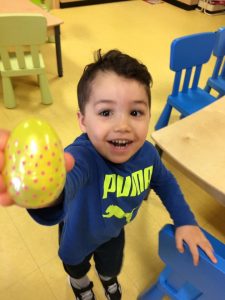 Toddler giving a big smile and showing an easter egg