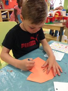 Kid drawing on an orange shirt