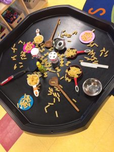 Uncooked pasta and cooking utencils on a table