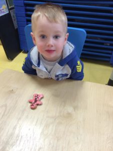 Little kid with a pink cookie 