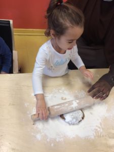 Kid rolling around dough and flour 