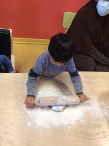 Child pressing firmly on dough