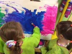 Little kids painting with blue and pink