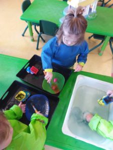 Kids playing with paint and toy cars