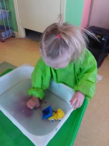 Toddler washing a toy truck nice and clean