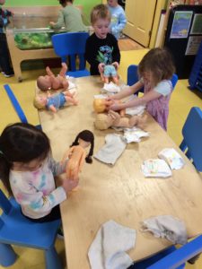 Kids learning about babies from baby dolls