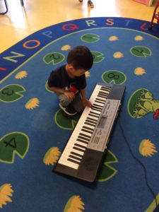 Kid tapping a piano key