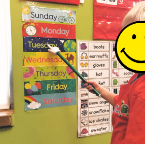 A Hopper Helper is pointing out the days of the week to their friends@