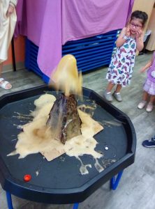 Kid looking spooked at a science experiement volcano eruption