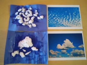 Toddlers replicating clouds with blue painted paper and cotton