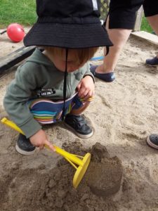 Toddler destroying sand castle