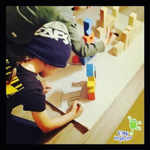 Toddler drawing an image with building blocks around