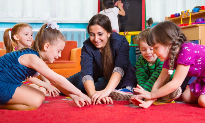 Daycare attendee sitting with children