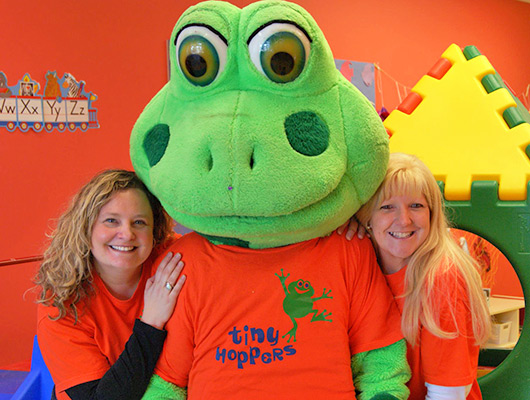Business owners pose with the Tiny Hoppers mascot