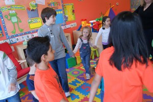 Children and supervisors play in a circle