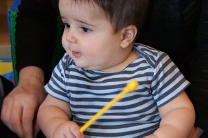 A child plays with a drum stick