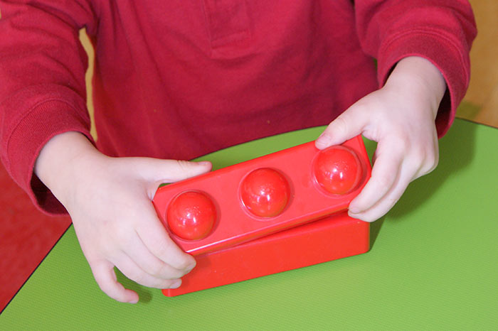 A close-up of a child's hands playing with blocks