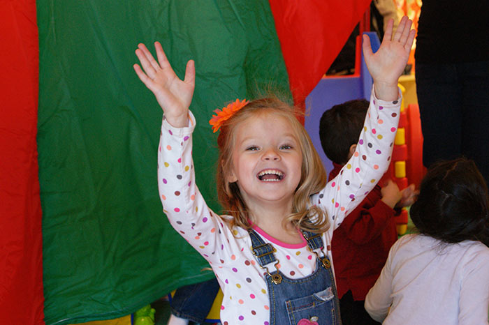 A young girl plays with a parachute