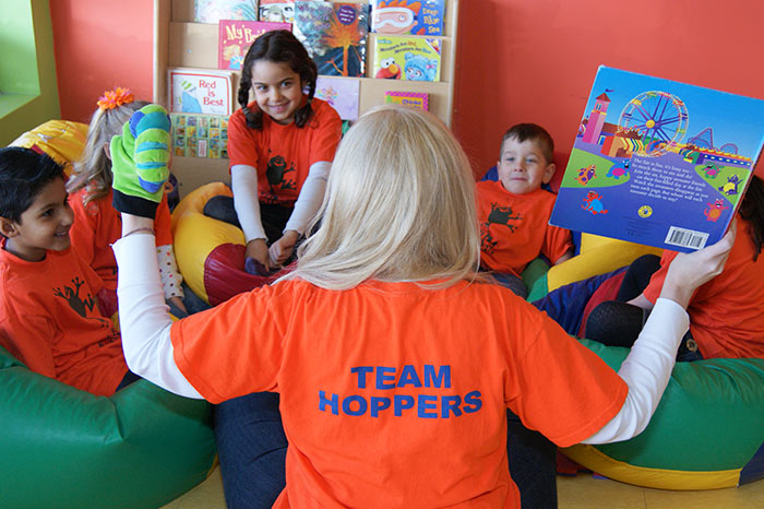 A staff member reads to a circle of children